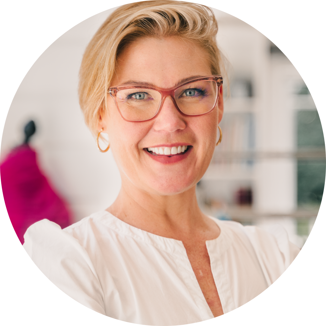 Jessie Sadler, a woman with short blonde hair, red glasses and a white blouse